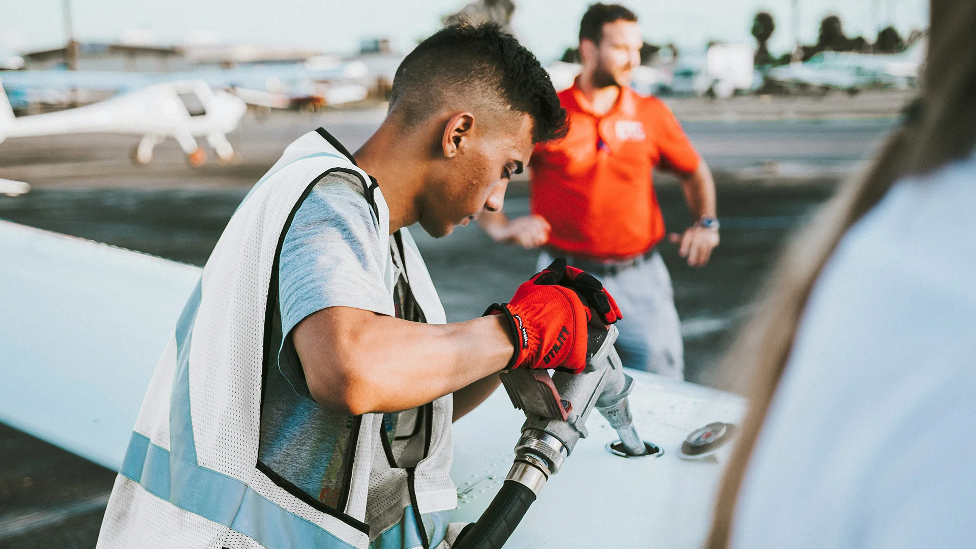 Young male filling up aeroplane with fuel on the tarmac